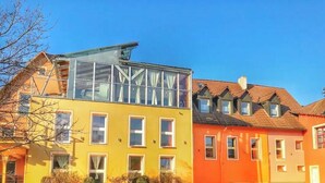 A row of colorful buildings with multiple windows and a clear sky.