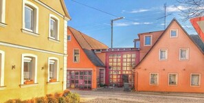 A street view with buildings, a cobblestone road, and a clear sky.