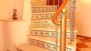 Escadaria em espiral com grades elaboradas e degraus estampados.
