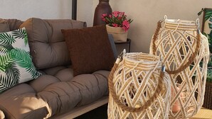 Um sofá marrom com um travesseiro de folha verde, um travesseiro marrom e duas cestas trançadas sobre uma mesa de madeira.