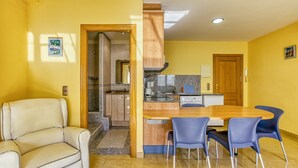 Un espace de vie compact comprenant une cuisine, un coin repas et un espace salon.