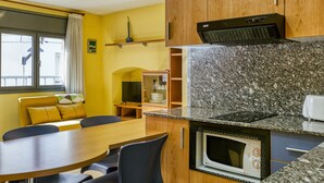 Une cuisine compacte équipée d’un four à micro-ondes, d’un four traditionnel et d’un petit four à micro-ondes encastré dans le plan de travail.