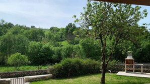 A patio area with a stone wall, a metal gate, and a grassy lawn. - Impeccable 3-Bed House in Cangas de Onis (Cangas de Onis)