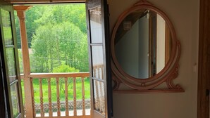 An open doorway leading to a balcony with a wooden railing, a large mirror on the wall, and a ceiling fan. - Impeccable 3-Bed House in Cangas de Onis (Cangas de Onis)