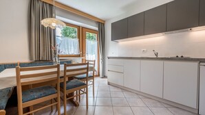 Eine Küche mit weißen Schränken, einer Arbeitsplatte und einem Fenster mit Vorhängen.