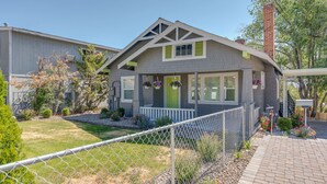 A two-story house with a grey exterior, a green door, and a small porch. - Cheerful 1-Bedroom with free parking (Reno)