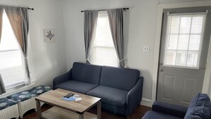 Una sala de estar con un sofá, una mesa de centro y un banco.