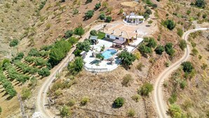 Una propiedad residencial con piscina, patio cercado y un paisaje montañoso.