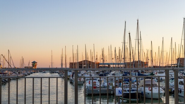 A marina with multiple boats docked, a lighthouse, and a building with a distinctive roof. - Apartment 'Perla Marina' with Garden & Terrace (grosseto)