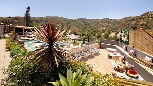 A pool area with lounge chairs, a dining table with food, and a mountainous backdrop. - Country House 'Quinta Do Silêncio T2' with Mountain View, Wi-Fi and Air Conditioning (Tavira)