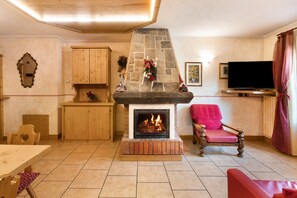 A cozy living room with a fireplace, wooden furniture, and a television.