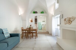 Un intérieur moderne avec un coin repas, un canapé et une cuisine en arrière-plan.