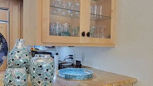 A kitchen with wooden cabinets, a dishwasher, and a countertop with decorative items.