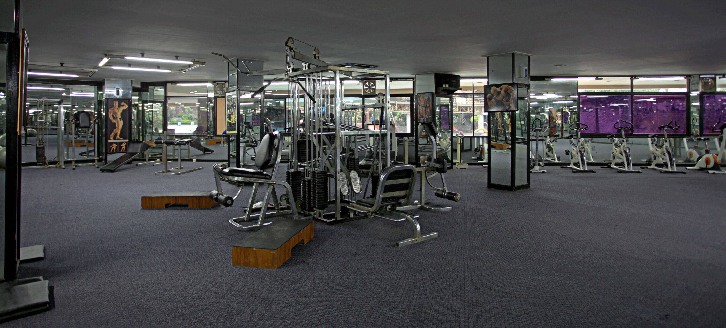 Uma academia com diversos equipamentos de exercício, incluindo aparelhos de musculação e esteiras.