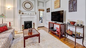 Una sala de estar con chimenea, televisor y mesa de centro.