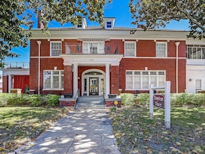 A two-story brick building with a central entrance, a balcony on the second floor, and a sign indicating 'Drayton Place'.