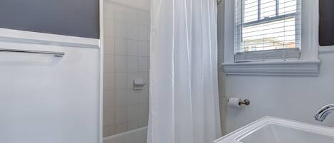 A bathroom with a bathtub, a shower, a toilet, and a sink.