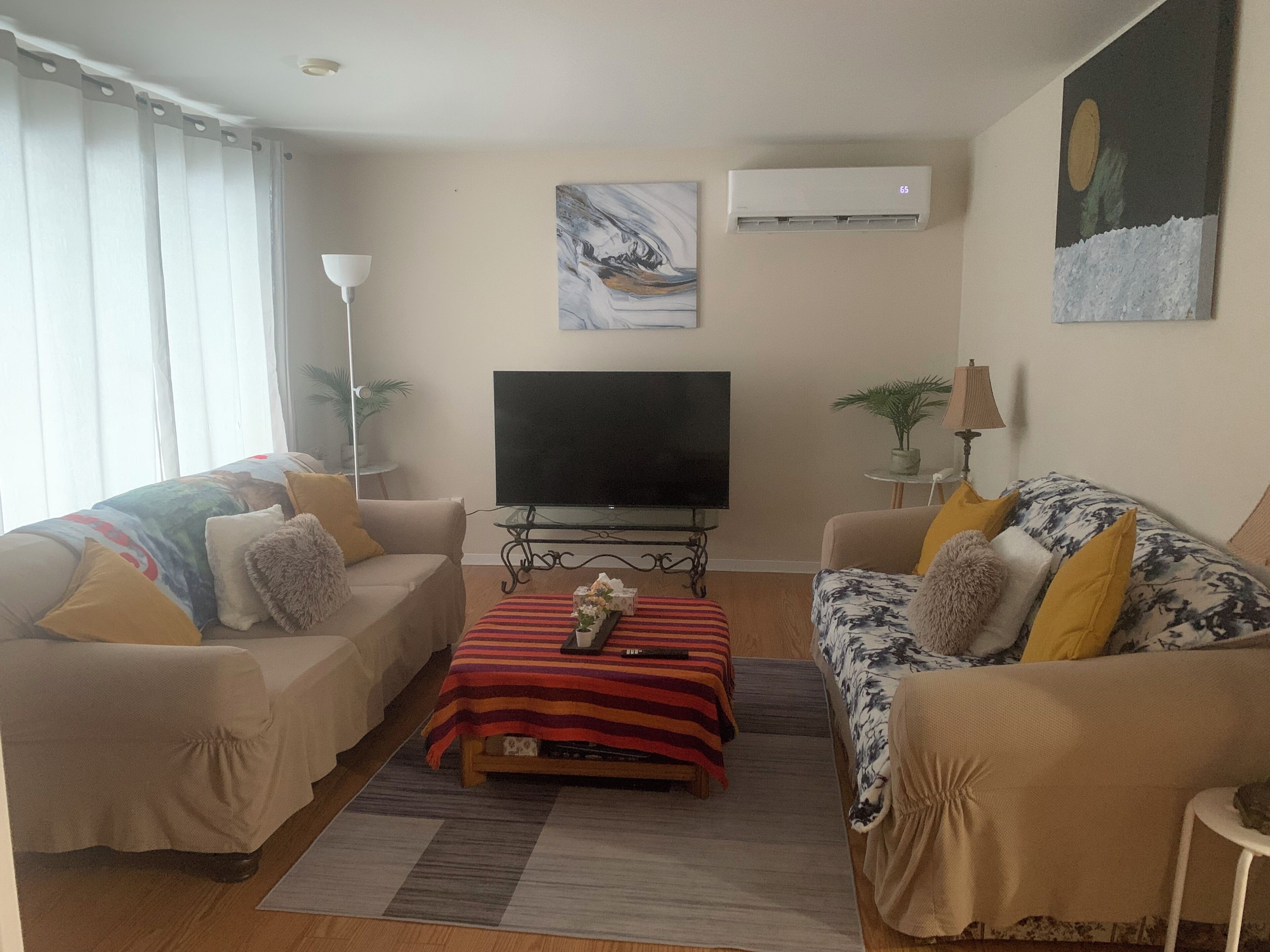Uma sala de estar com dois sofás, uma televisão e uma mesa de centro.