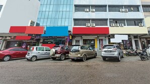 Un immeuble à plusieurs étages, dont le rez-de-chaussée abrite plusieurs commerces, notamment un restaurant bien visible et un hôtel.