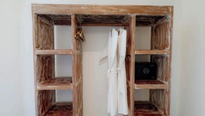 A wooden wardrobe with multiple compartments, including hanging space and shelves. - Tanta Escape (Sebatu)