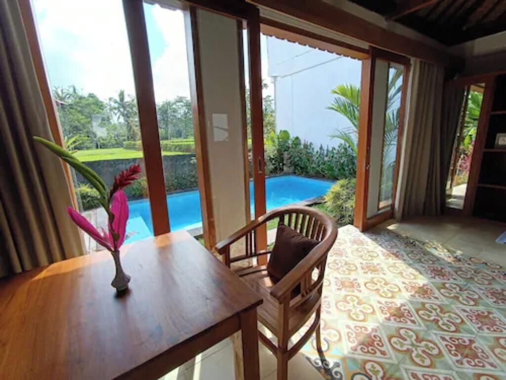 Una piscina al aire libre, sombrillas, sillones reclinables de piscina