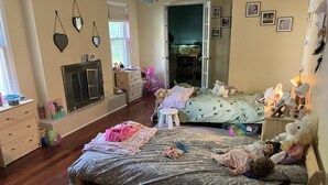 Une chambre confortable avec deux lits, une commode, une fenêtre avec des rideaux et un aquarium dans un coin.