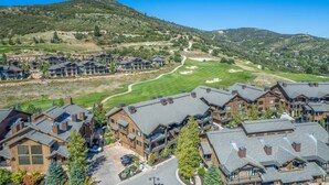 A residential area with modern houses, a golf course, and a hilly landscape.