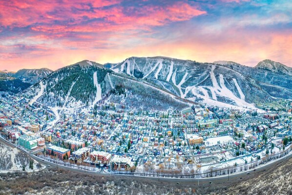 A town with a dense cluster of buildings, roads, and a mountainous backdrop.