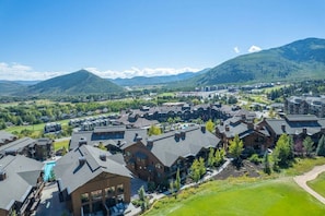 A residential area with multiple houses, a swimming pool, and a mountainous backdrop. - Juniper Landing (Park City)