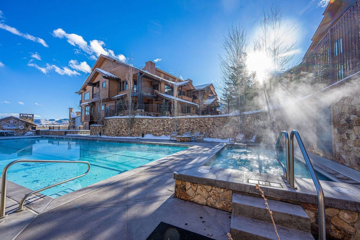 Ein Resort mit Schwimmbad, Whirlpool und einer Steinmauer.