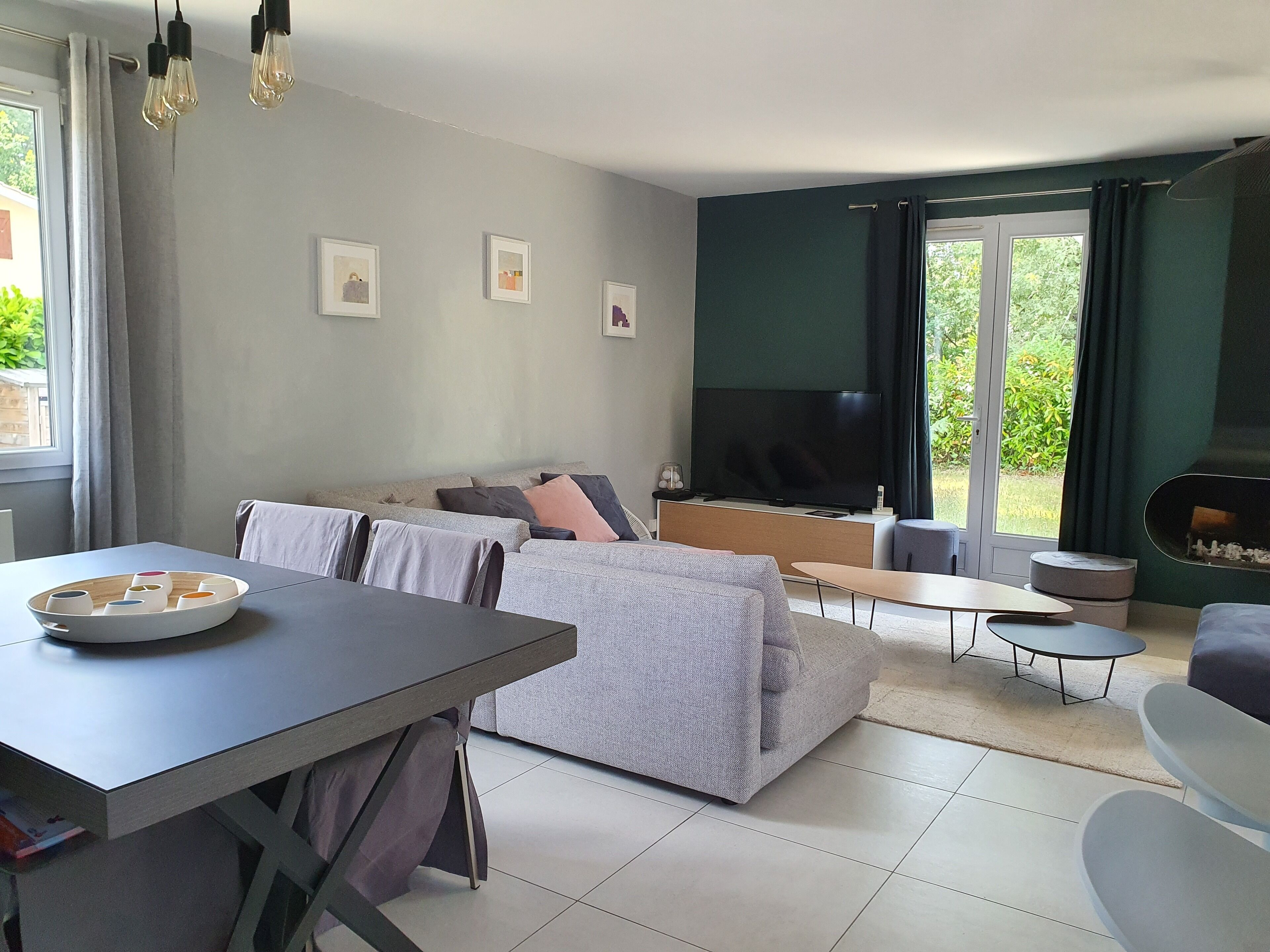 Un salon moderne avec un canapé, un téléviseur et une table à manger.