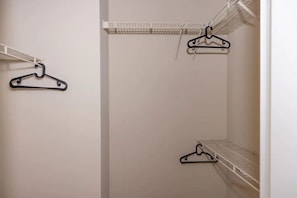 Ample storage space for your belongings, featuring three shelves with hanging rods.