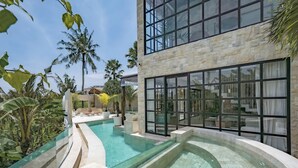 A modern building with large windows and a swimming pool. - Rumah Simba (Munggu)
