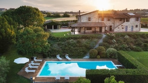 Uma villa com piscina, espreguiçadeiras e jardim.