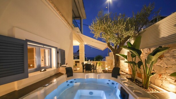 A hot tub in an outdoor patio area with a stone wall and a tree. - Donna Lucia Romantic Villa w/ jacuzzi Sea Front (Monopoli)
