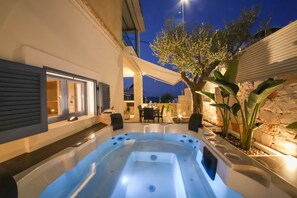 A hot tub in an outdoor patio area with a stone wall and a tree. - "Donna Lucia," a romantic villa with a hot tub, right on the beach (Monopoli)