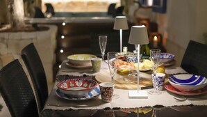 A dining table set with various dishes, glasses, and a lamp. - Donna Lucia Romantic Villa w/ jacuzzi Sea Front (Monopoli)