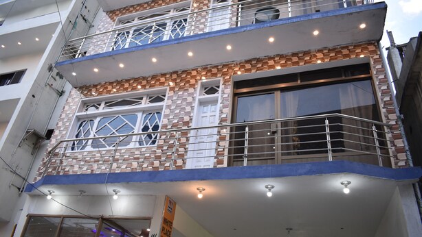A multi-story building with a brick facade, balconies, and a sign indicating it is a hotel.