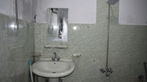 A bathroom with a sink, mirror, and shower.
