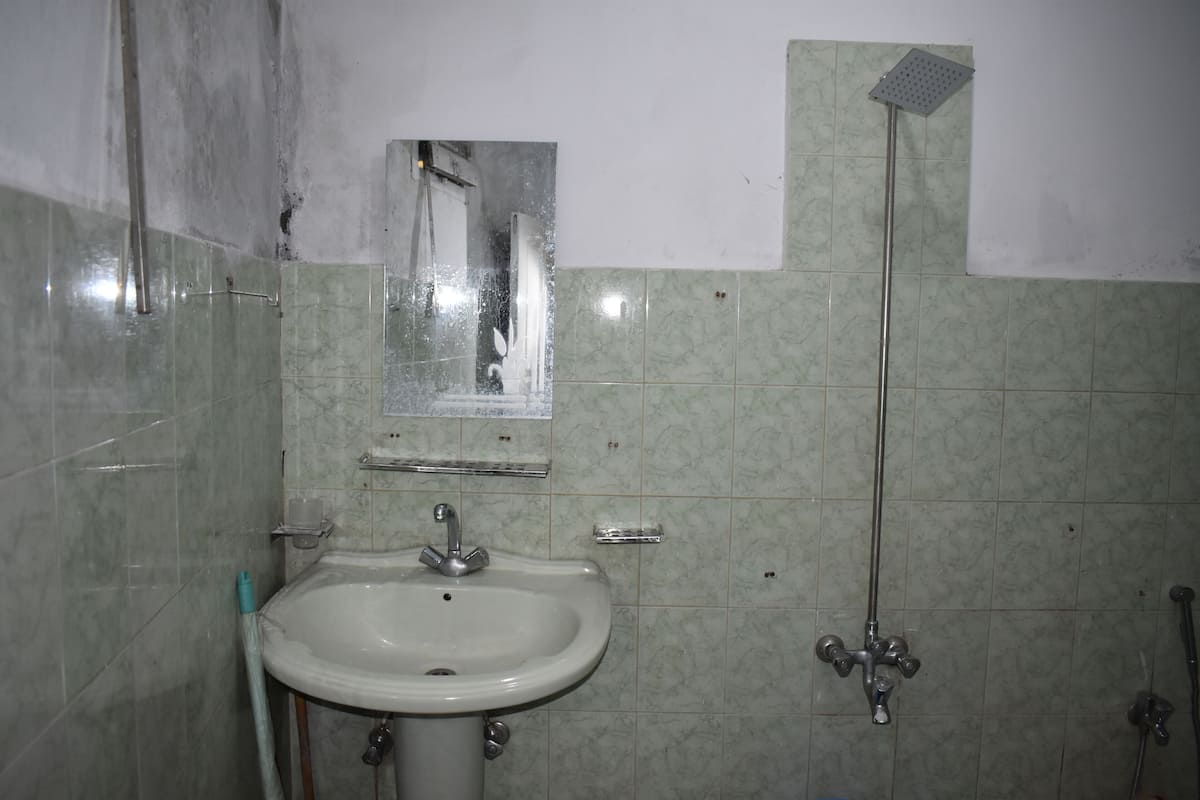 Une salle de bain avec un lavabo, un miroir et une douche.