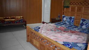 A bedroom with a wooden bed, a nightstand, and a door.