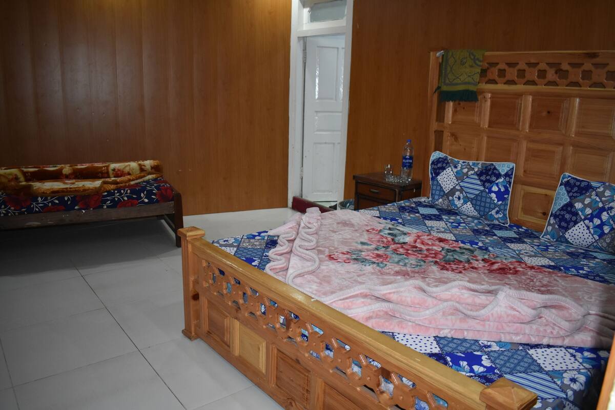 Une chambre à coucher avec un lit en bois, une table de chevet et une porte.