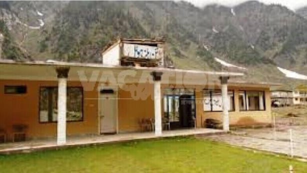 A building with a flat roof, a front entrance, and a sign above the door. - Frontier Hotel (Balakot)