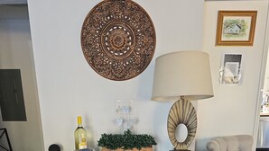 Eine Holzkommode mit mehreren Schubladen, ein Wandbehang, eine Lampe und ein gerahmtes Bild an der Wand.