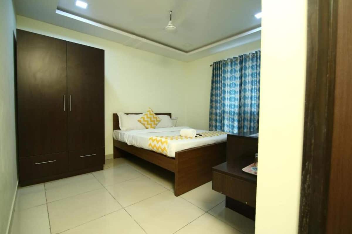 Quarto com cama, guarda-roupa e escrivaninha.