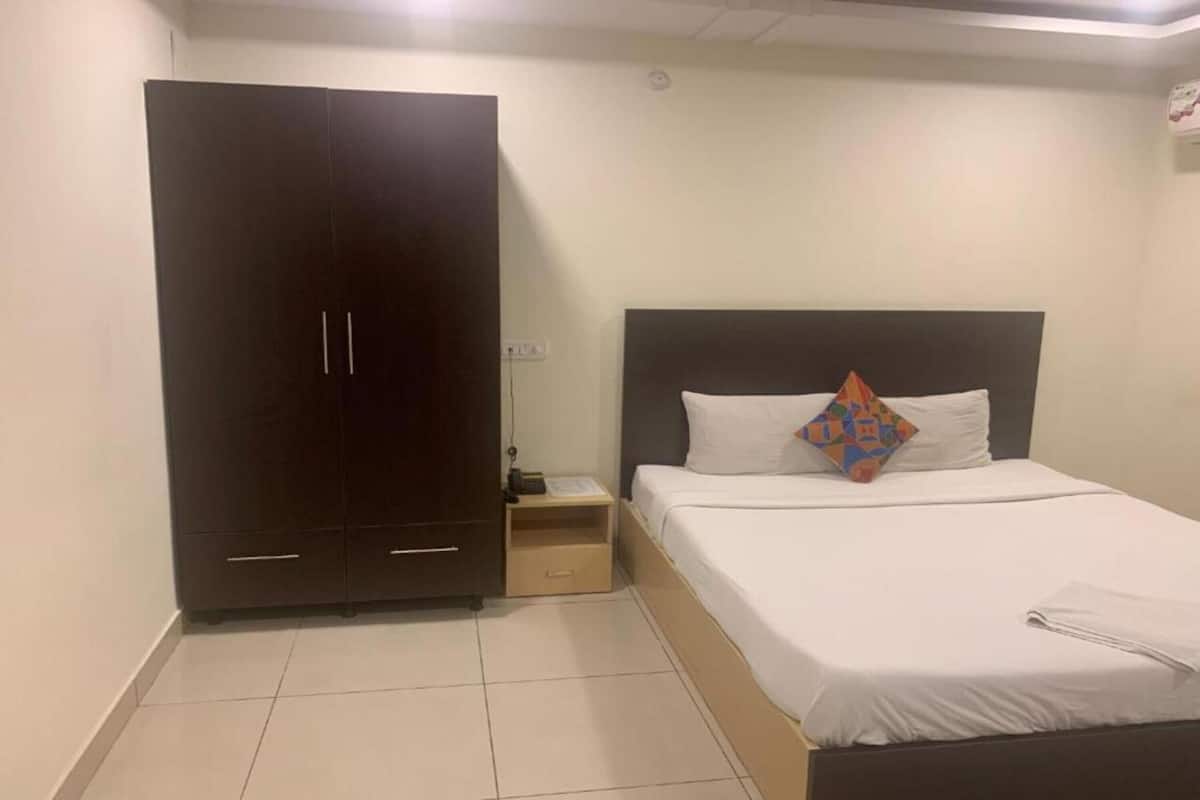 Um quarto com uma cama, um guarda-roupa e uma mesa de cabeceira.
