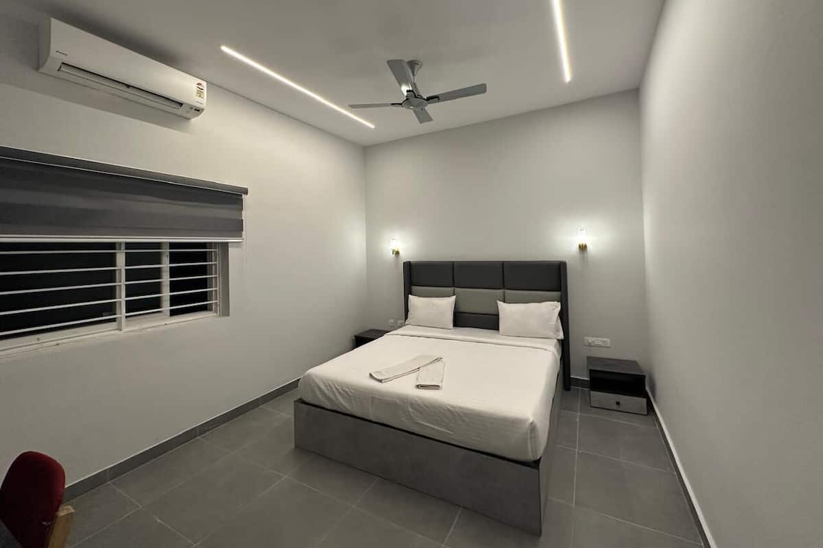 Quarto moderno com uma cama grande, um ventilador de teto e uma janela com persianas.