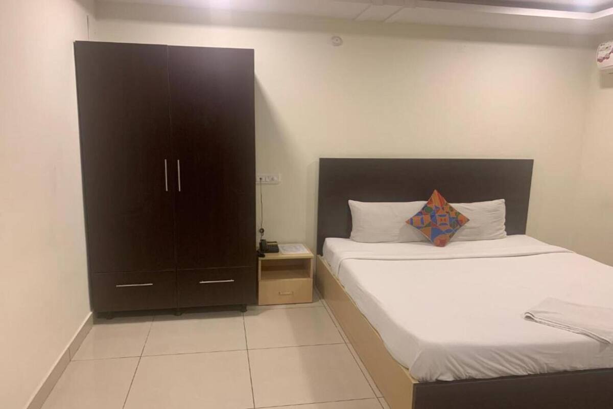 A bedroom with a bed, a wardrobe, and a nightstand.