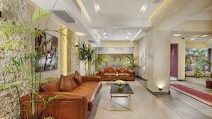 A spacious lobby with a brown leather sofa, a glass coffee table, and potted plants. - Vibotel Residence Hotel Apartments (New Cairo)
