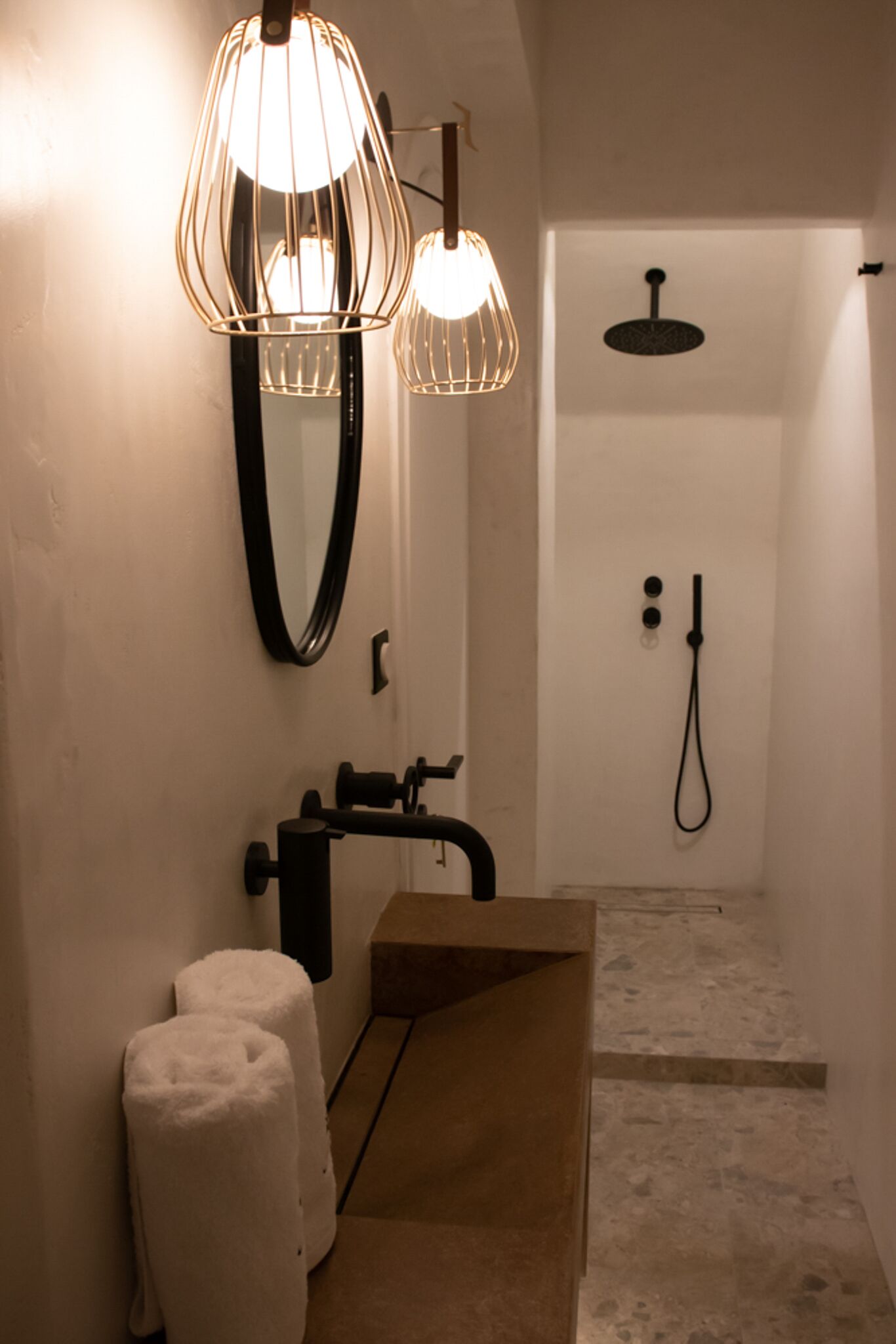 A modern bathroom with a large mirror, a sink, and a shower.